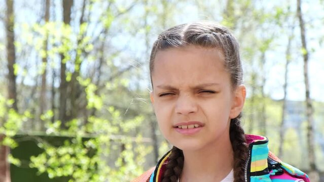 cute teenage girl squints because of poor eyesight street, child with poor eyesight selection of glasses to improve vision
