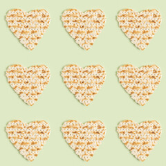 Seamless pattern with heart made from matzah for Jewish holiday Pesach on green background.
