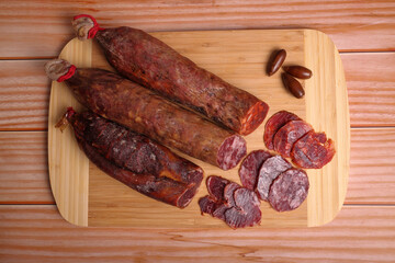 Iberian sausage, Iberian chorizo and Iberian tenderloin on cutting board and wooden table.