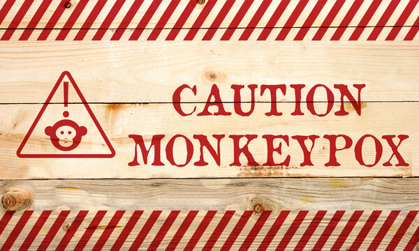 caution monkeypox on wooden background
