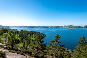 Fototapeta na wymiar A spectacular view clear blue waters of Gandsfjord fjord and Stavanger suburbs coastline while hiking to Lifjel mountain, Norway, May 2018