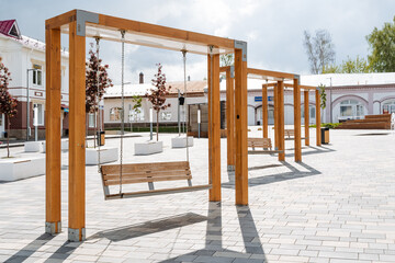 Outdoor swings of modern design, a town square, a place of rest for citizens, wooden benches,...