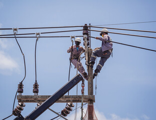 Electricians is repairing high voltage wires on electric power pole