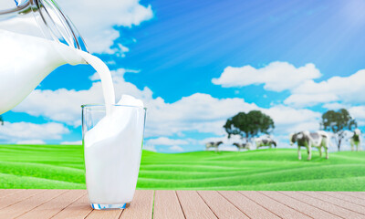 Pour fresh milk from the jug into a clear milk glass placed on a wooden plank floor. Bright green...