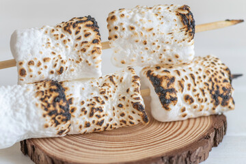 Roasted marshmallow on wooden background.