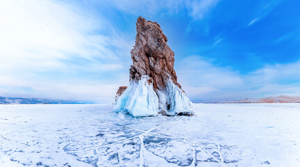 Beautiful winter landscape island Ogoy frozen lake Baikal with transparent cracked blue ice sunset light