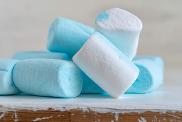 Blue and white marshmallow on wooden background.