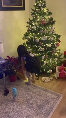 una niña abriendo los regalos de navidad 