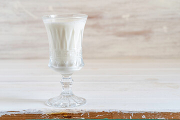 Glass of milk on white wooden background with copy space.
