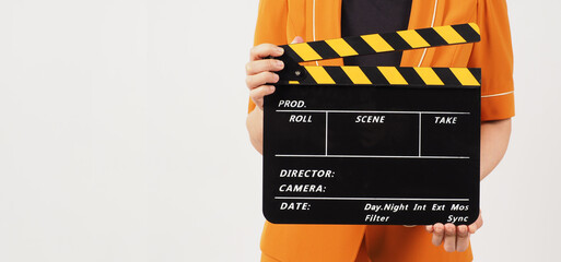 The woman's body part hold a Black and yellow Clapperboard  and she wears a yellow mustard suit on...