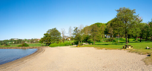 A small beach and recreational park at Hafrsfjord fjord near Sword in Rock monument, Stavanger, Norway, May 2018