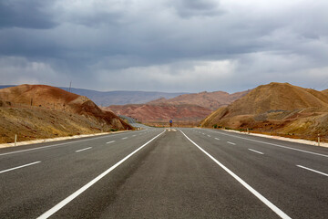 yellow and brown mountains and the highway passing through