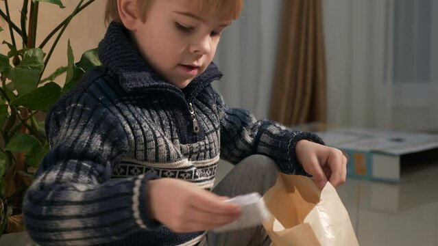 Kid Unboxing Present at Home. Child Open Box with Toy. Slow motion 4K