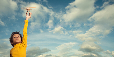   Little African American child playing airplane, outdoor portrait