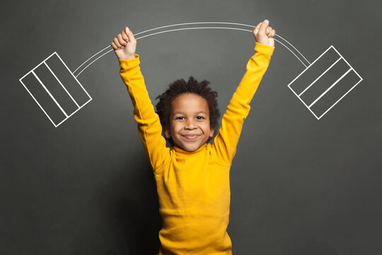 Funny Strong Black Kid With Barbell In Her Hands On Chalkboard Background