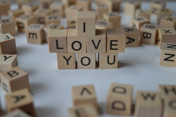 I love you written with wooden cubes surrounded by a bunch of other cubes with letters, expressing feelings towards others