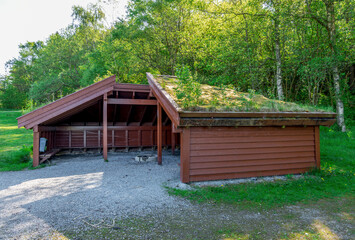 A roof covered shelter hut with a campfire circle in the middle in Halandsvatnet lake park, Stavanger, Norway, May 2018