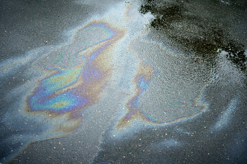 Gasoline oil spill on the pavement as a texture or background. Environmental pollution concept