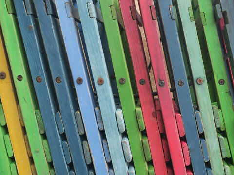 row of multicolored wooden chairs near a terrace in Amsterdam