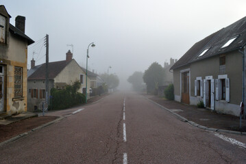 Fototapeta na wymiar View of Old French Village Buildings and Road on Misty Morning