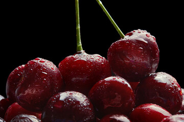 Cherries in the bowl on black background covered with fine water splashes. Fresh Cherry