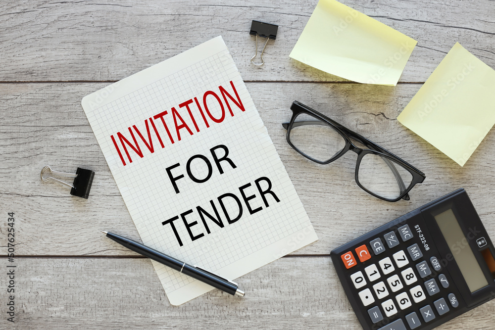Poster invitation for tender . torn sheet of paper from a notebook with text on the desktop. business conce
