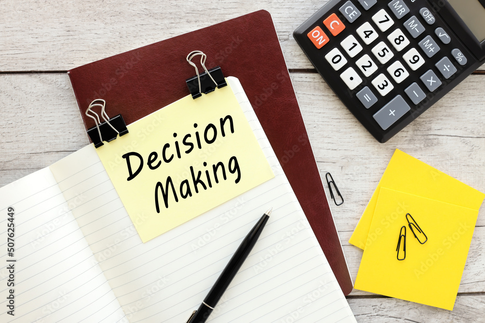 Poster decision making . text on yellow note on red notepad near calculator