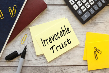 Irrevocable trust . text on yellow sticky note near different stationery