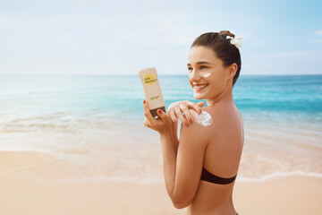 Woman putting sunblock lotion on shoulder before tanning during summer holiday on beach vacation...