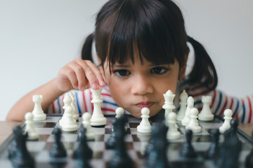 Asian little girl playing chess at home.a game of chess