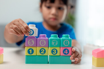 Little child girl playing colorful blocks