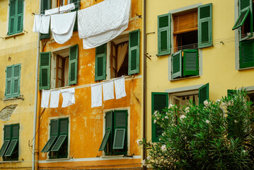 Green windows and drying white clothes in typical town of Riomaggiore, Cinque Terre
