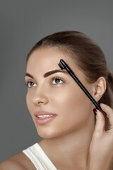 Fototapeta premium Eyebrows correction. Shape. Beautiful young woman with perfect natural eyebrows and eyelashes. Natural make up. Beauty. Eyebrows and eyelashes close up