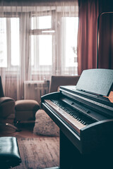 Electronic piano in the interior of the room on a blurred background.