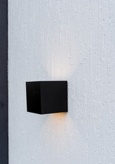 Miniature ice lamp on the wall of the house, facade lighting on the white wall, designer lamp of...