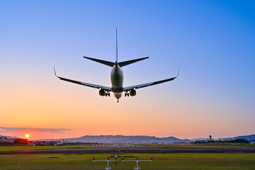美しい夕焼けと着陸する飛行機
