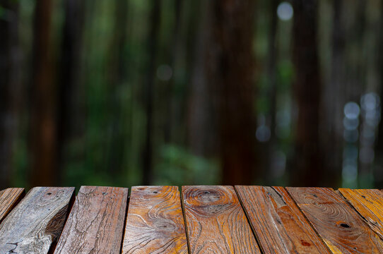 Old teak wood empty table in front of Sumatran pine (Pinus merkusii), pine forest stands. Display product.