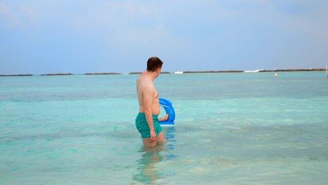 Joke. The father pushes the child out on the swimming circle and waves at him and leaves. A fun imitation of wires into the adult life of a small child