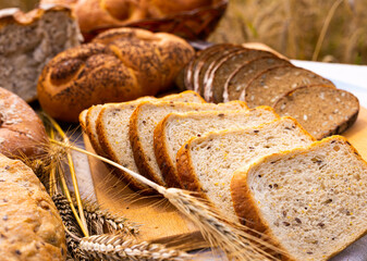 lot of different flavored bread, wheat, rye, on the table in the field outside