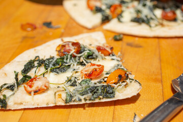 A closeup view of a slice of rustic Mediterranean flatbread.