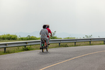 Obraz premium people riding bicycles, playing and exercising on vacation On the road and see the beautiful nature Thailand Dates 28-5-2022