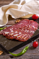 Turkish pastrami. Bacon made from ribeye meat. Beef pastrami sliced Pastirma or Turkish pastrami. Close-up.