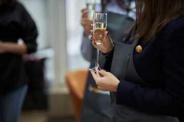 girl holding a glass of champagne in her hands at a party, close-up