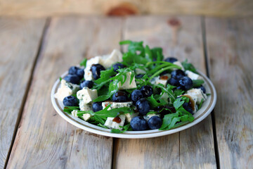 Delicious salad with blueberries and arugula. Fresh menu. Beautiful food. salad trend.