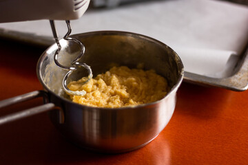 Close up of dough and electric mixer.