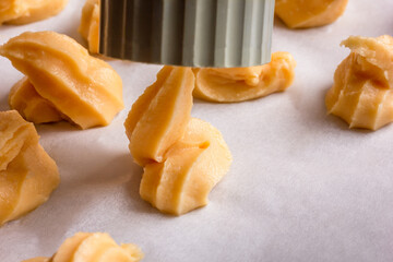 Profiteroles cooking, dough on a baking paper.