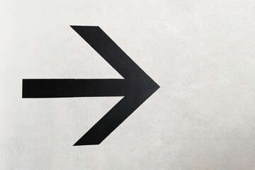 arrow direction on a white wall, black direction arrow on a white background for orientation on a concrete uneven wall, convenient for searching and evacuating people in case of fire,special sign