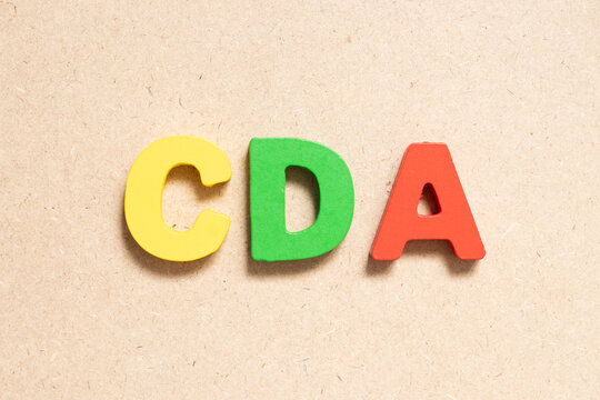 Color alphabet letter in word CDA (Abbreviation of Confidential disclosure agreement) on wood background