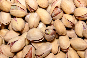 Pistachios texture and background . Tasty pistachios as background,as pistachios texture. flat lay. Nuts. A healthy snack. Vitamins and proteins. Nuts in the shell.