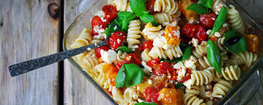 Soft focus. Feta tomato pasta with basil in a bowl.
